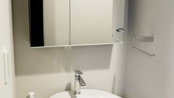 A bathroom with a white sink, a mirror, and a door.