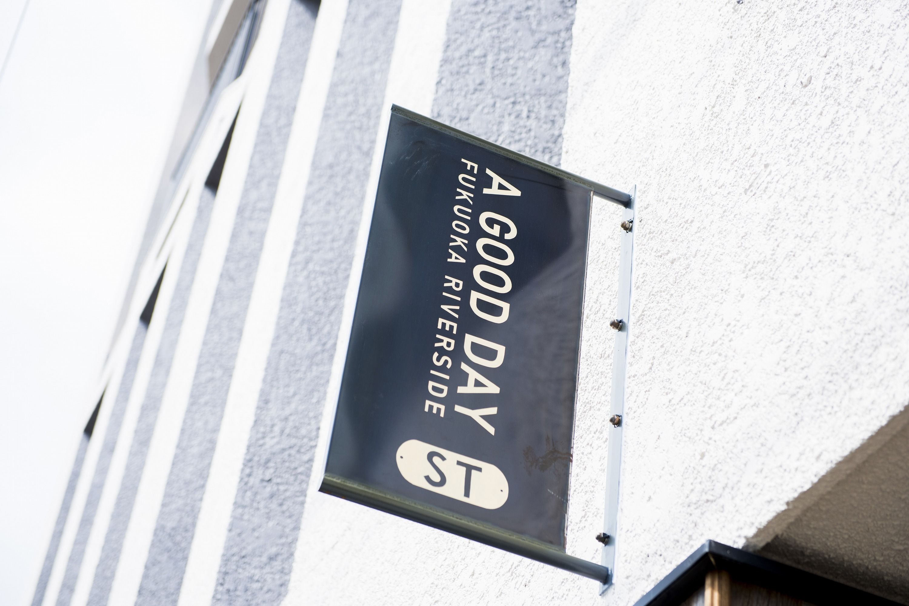 A sign on a building that reads "A Good Day Fukuoka Riverside ST."