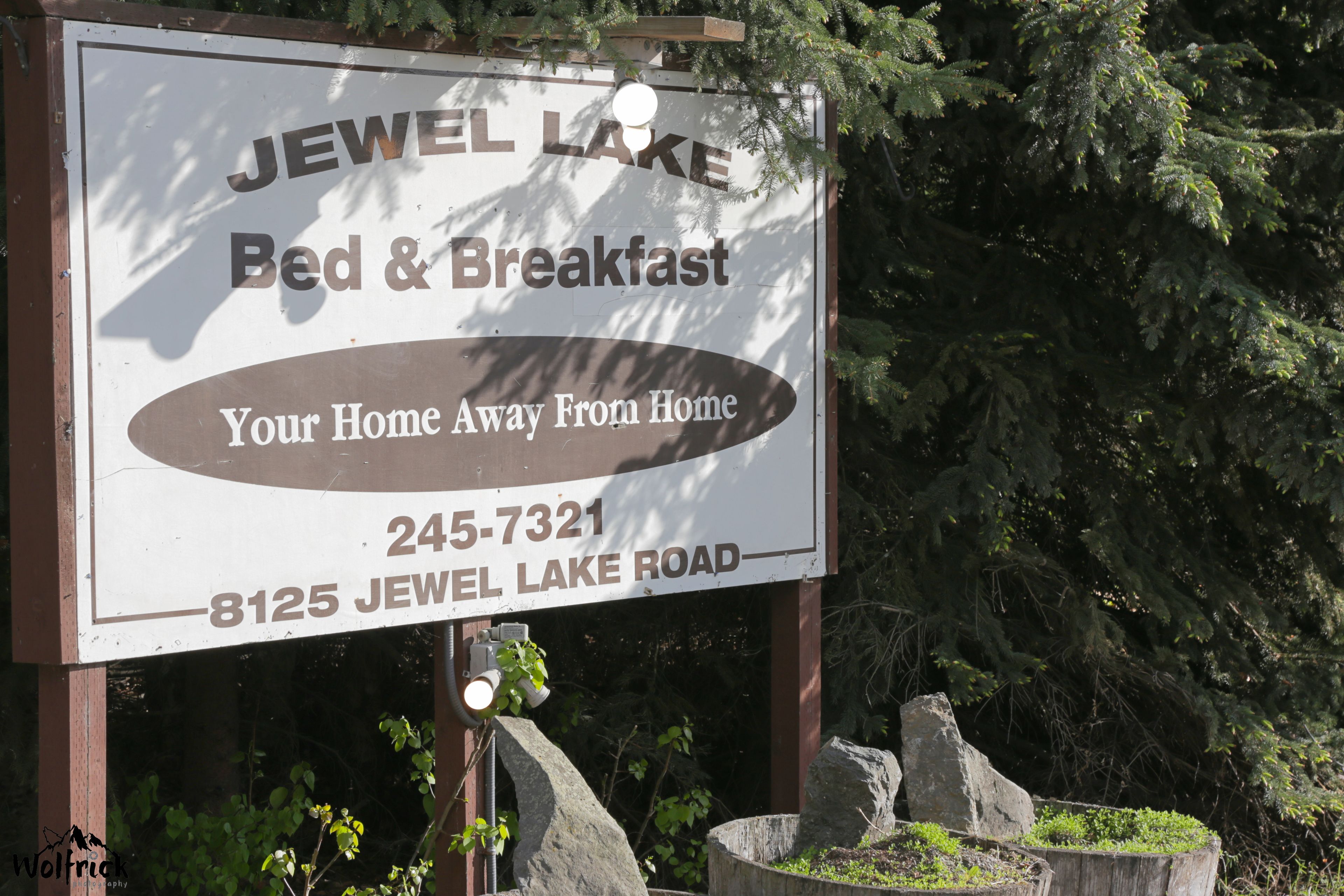 Placa para 'Jewel Lake Bed & Breakfast' com informações de contato e endereço.
