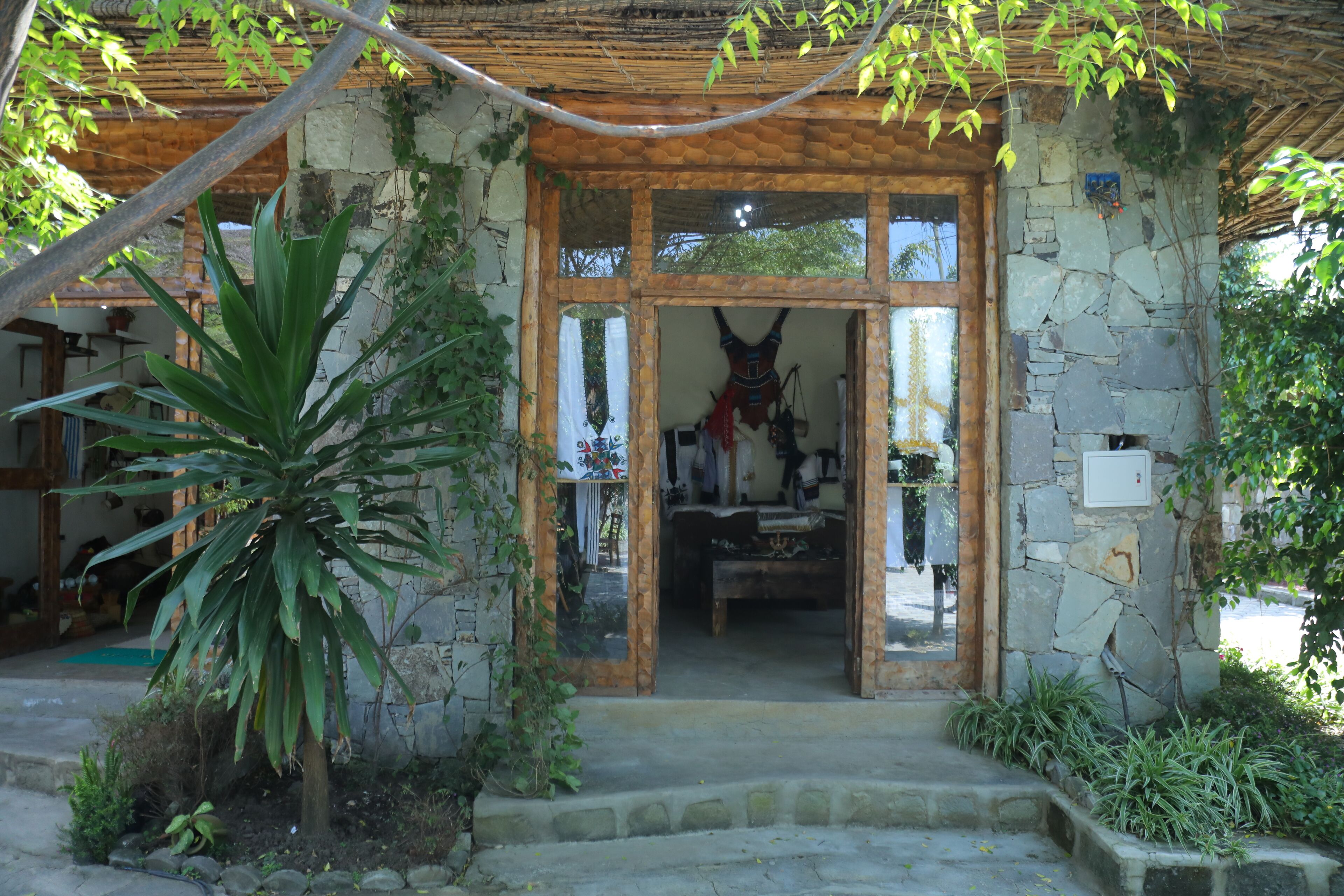 A rustic stone building with a wooden door and steps leading up to it.