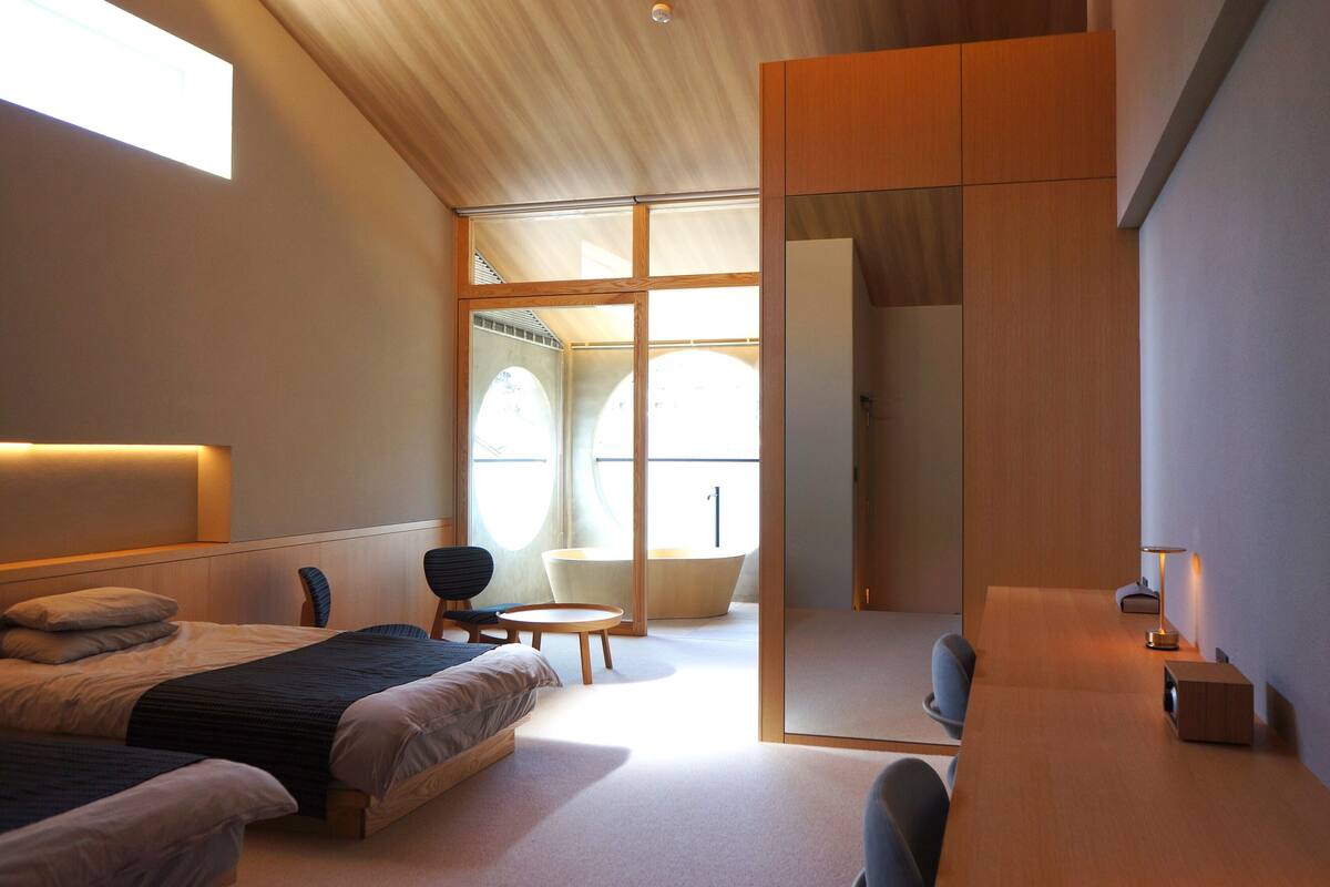 Ein modernes Schlafzimmer mit einem großen Bett, einem Schreibtisch und einer Badewanne.