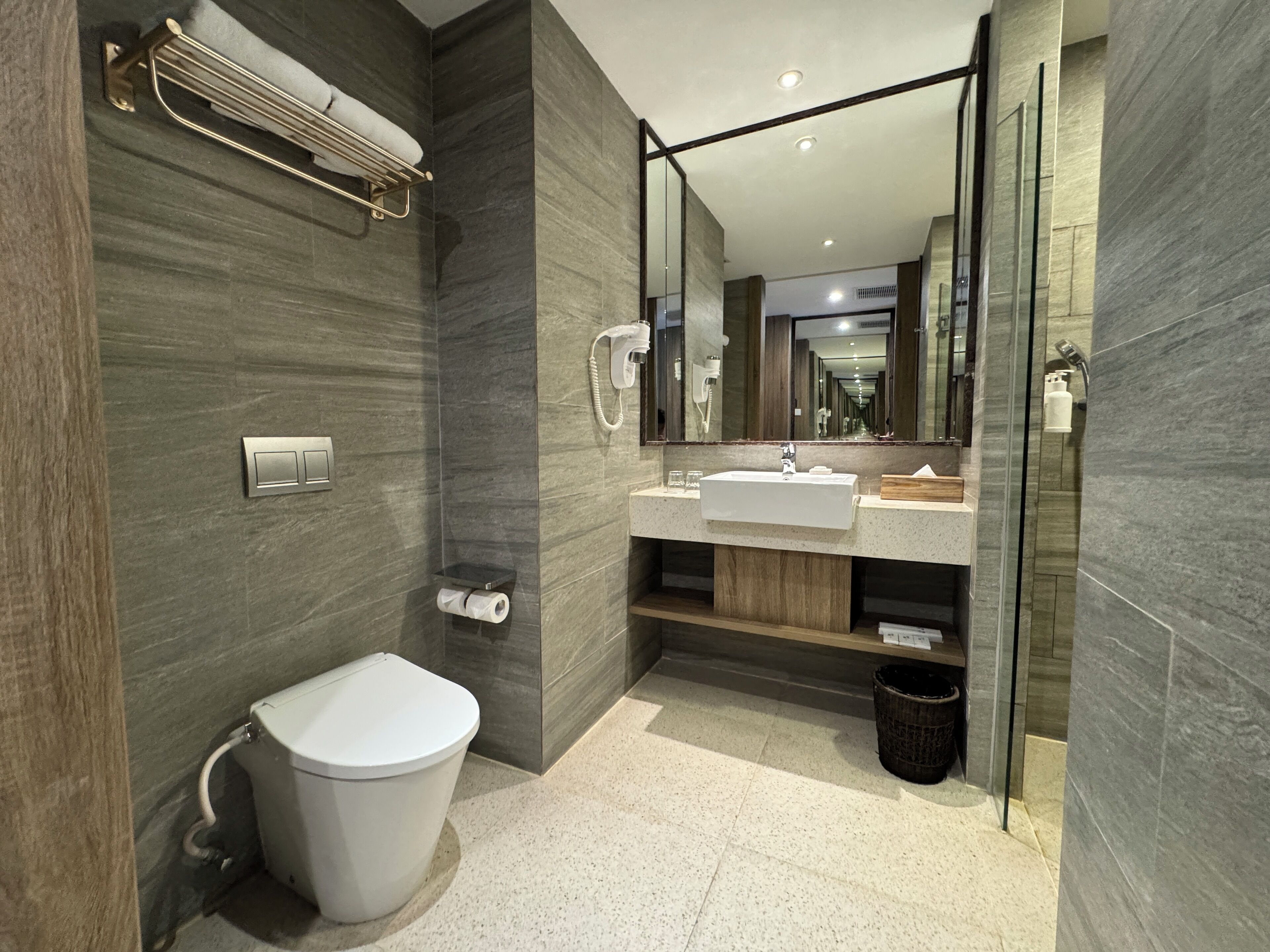 A modern bathroom with a toilet, sink, and shower.