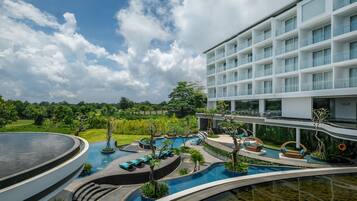 Um hotel moderno com área de piscina, incluindo espreguiçadeiras e um toboágua.