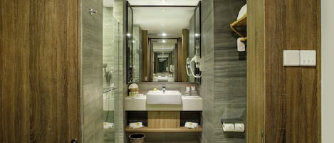 Une salle de bain moderne avec un meuble-lavabo en bois, une cabine de douche en verre et un miroir au-dessus du lavabo.