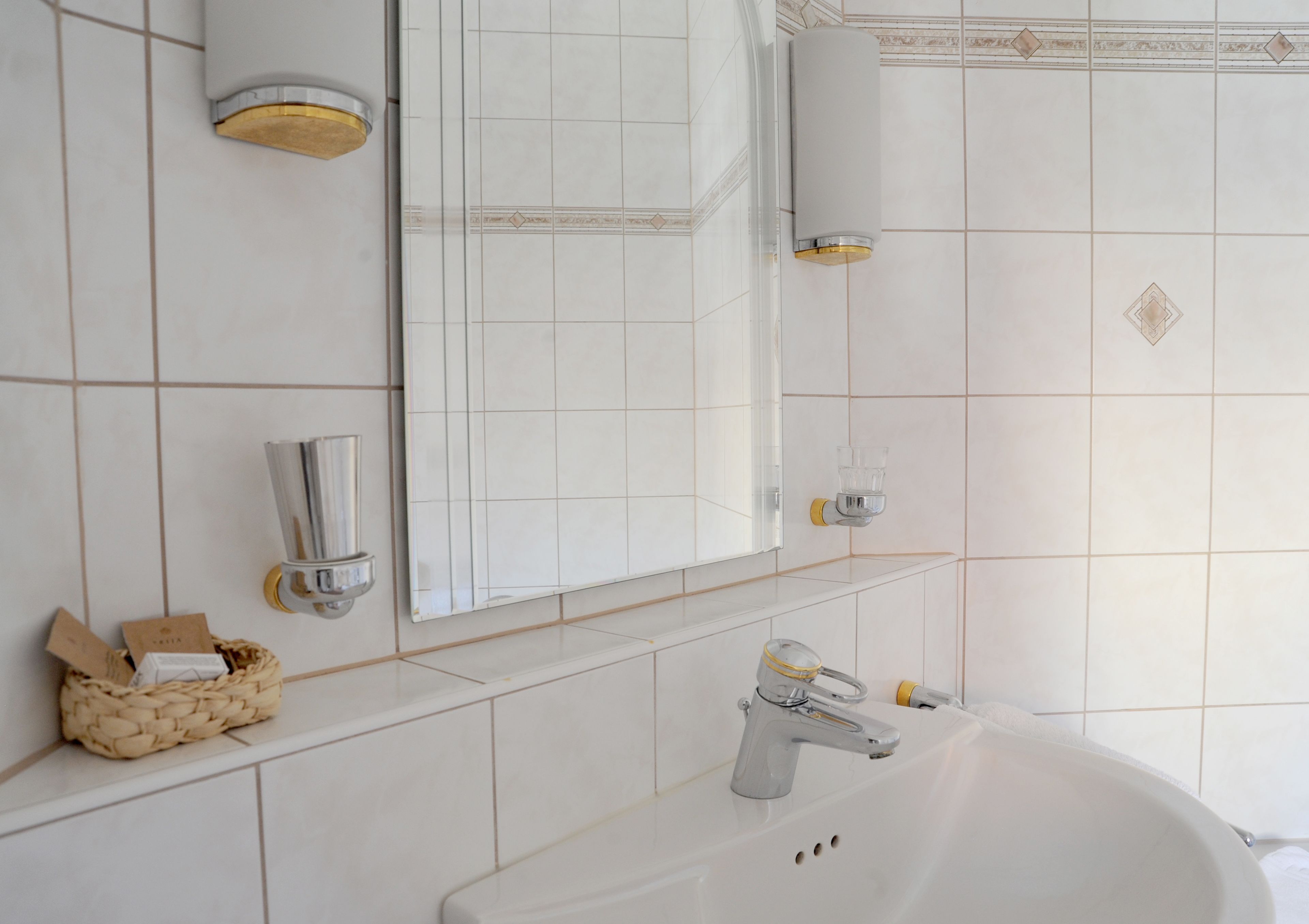 A bathroom with a white sink, a mirror, and a towel rack.