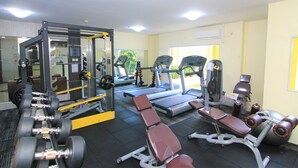 A gym with exercise equipment, benches, and a treadmill.