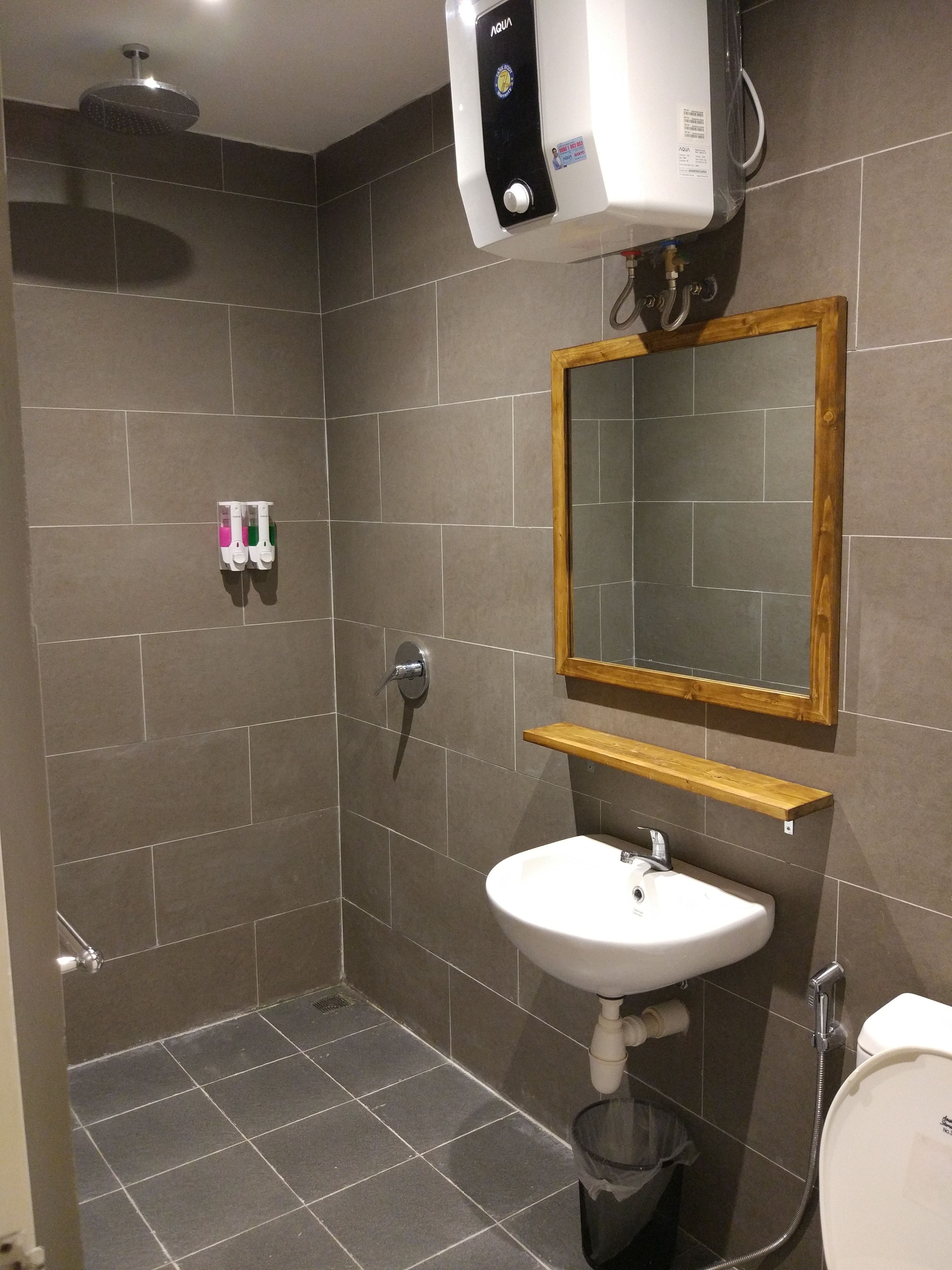 A modern bathroom with a shower, sink, and toilet.
