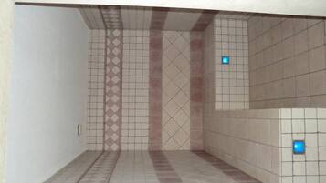 Bathroom features a tiled floor and walls with simple, repeating pattern.