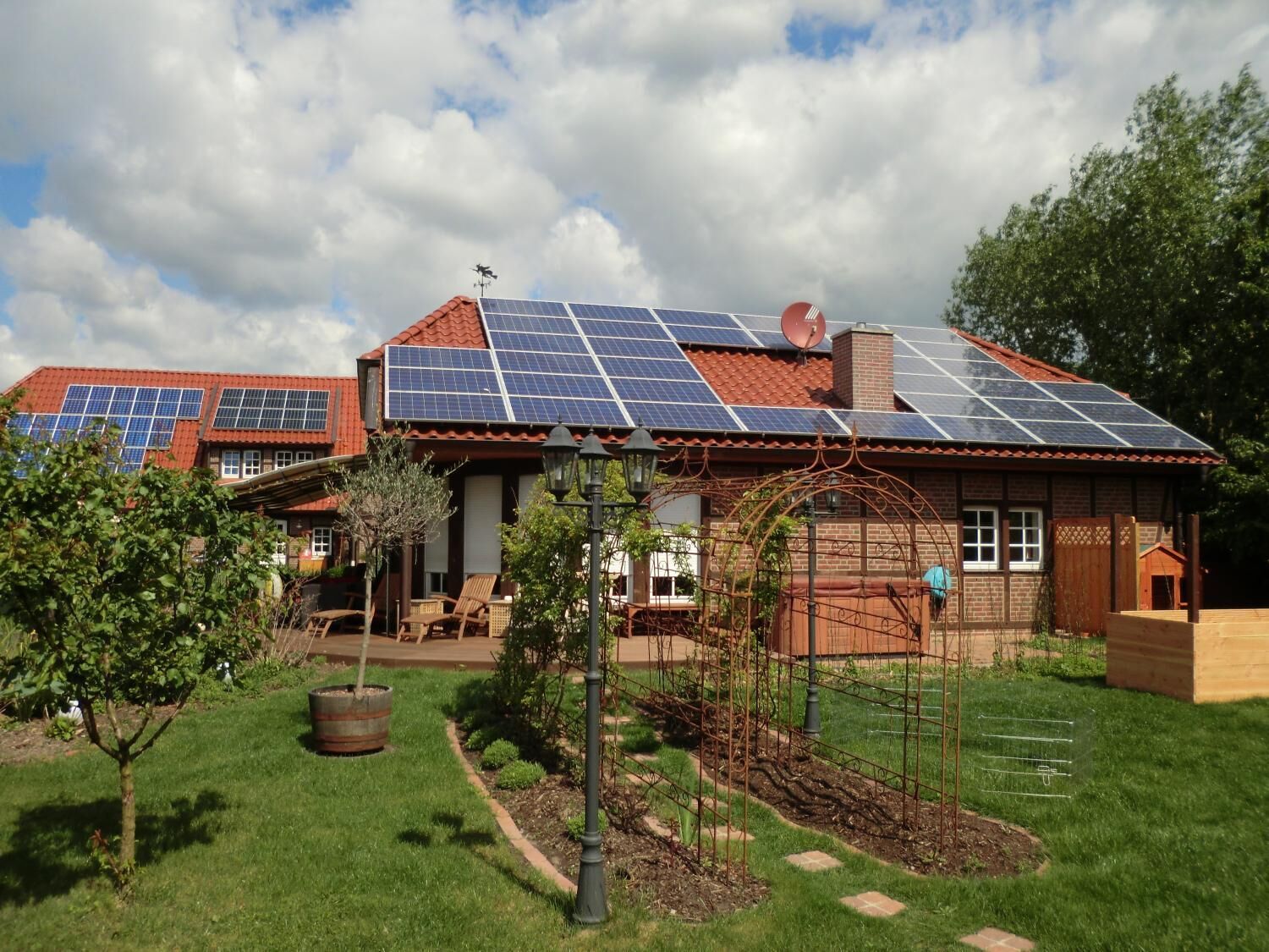 Una casa con techo rojo y paneles solares.