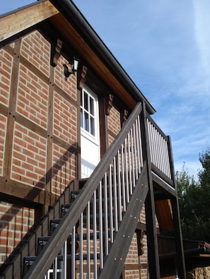 Un edificio de ladrillo con una escalera de madera y una ventana.