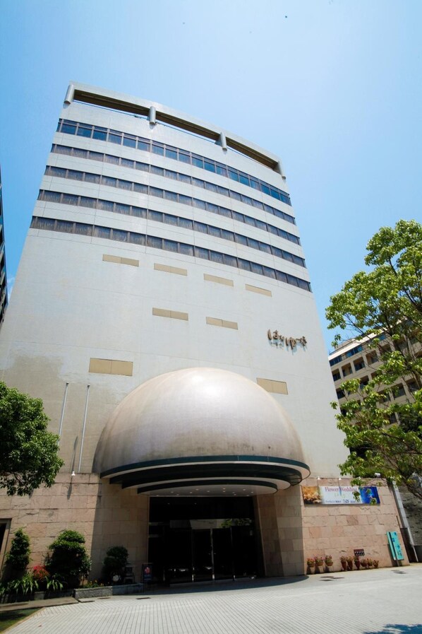 A modern building with a curved entrance and a large dome structure. - Hanayuzuki (Matsuyama)