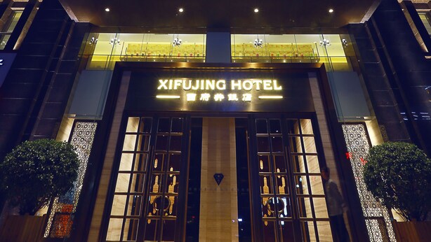 Un edificio de hotel alto con señalización iluminada y una fachada moderna.