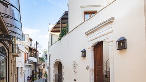 A narrow street with buildings, a clock, and a sign reading "Wladyslaw". - Z boutique Hotel (Mylopotamos)
