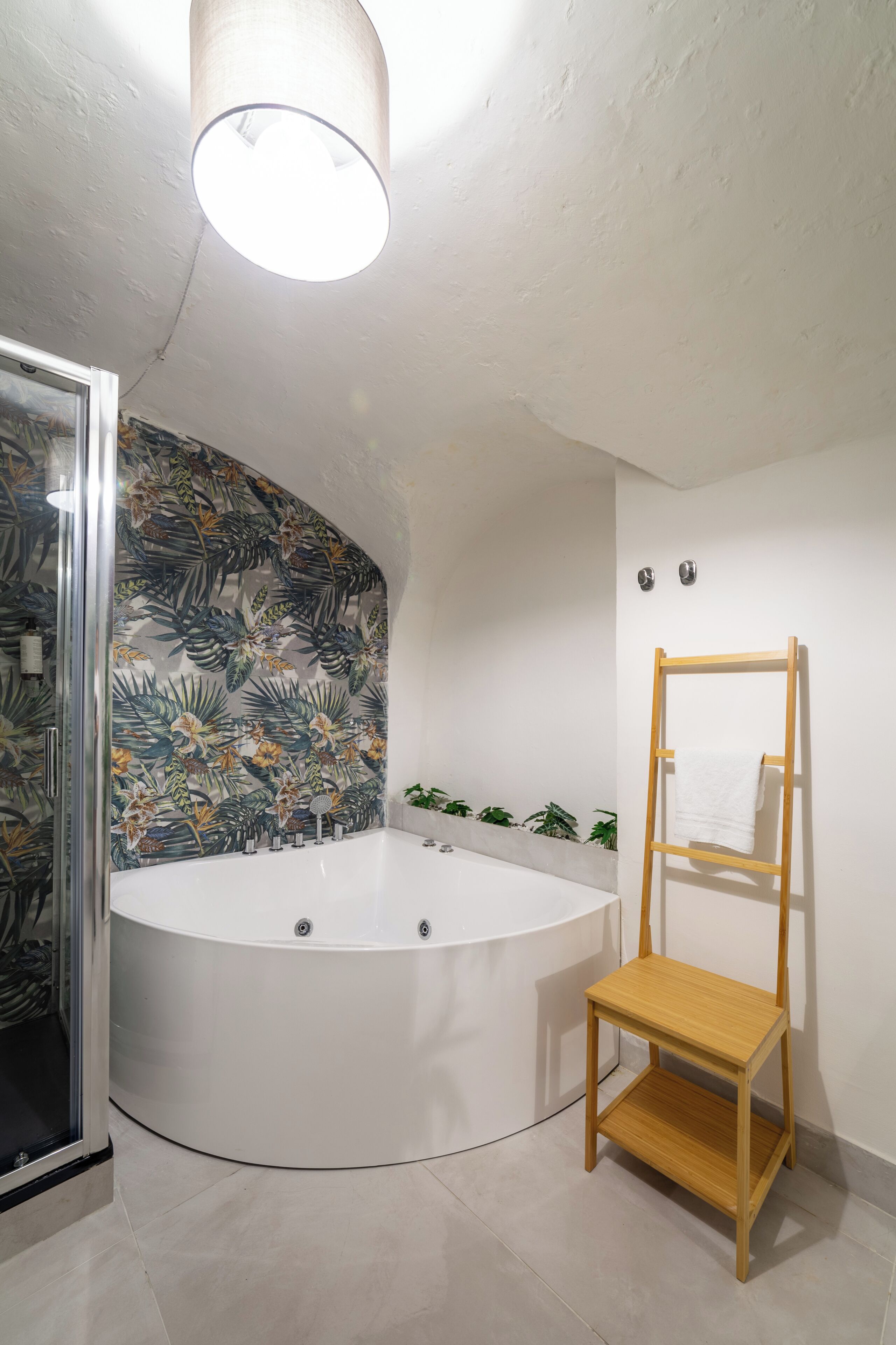 Un baño moderno con una bañera independiente, un estante de madera y una zona de ducha.