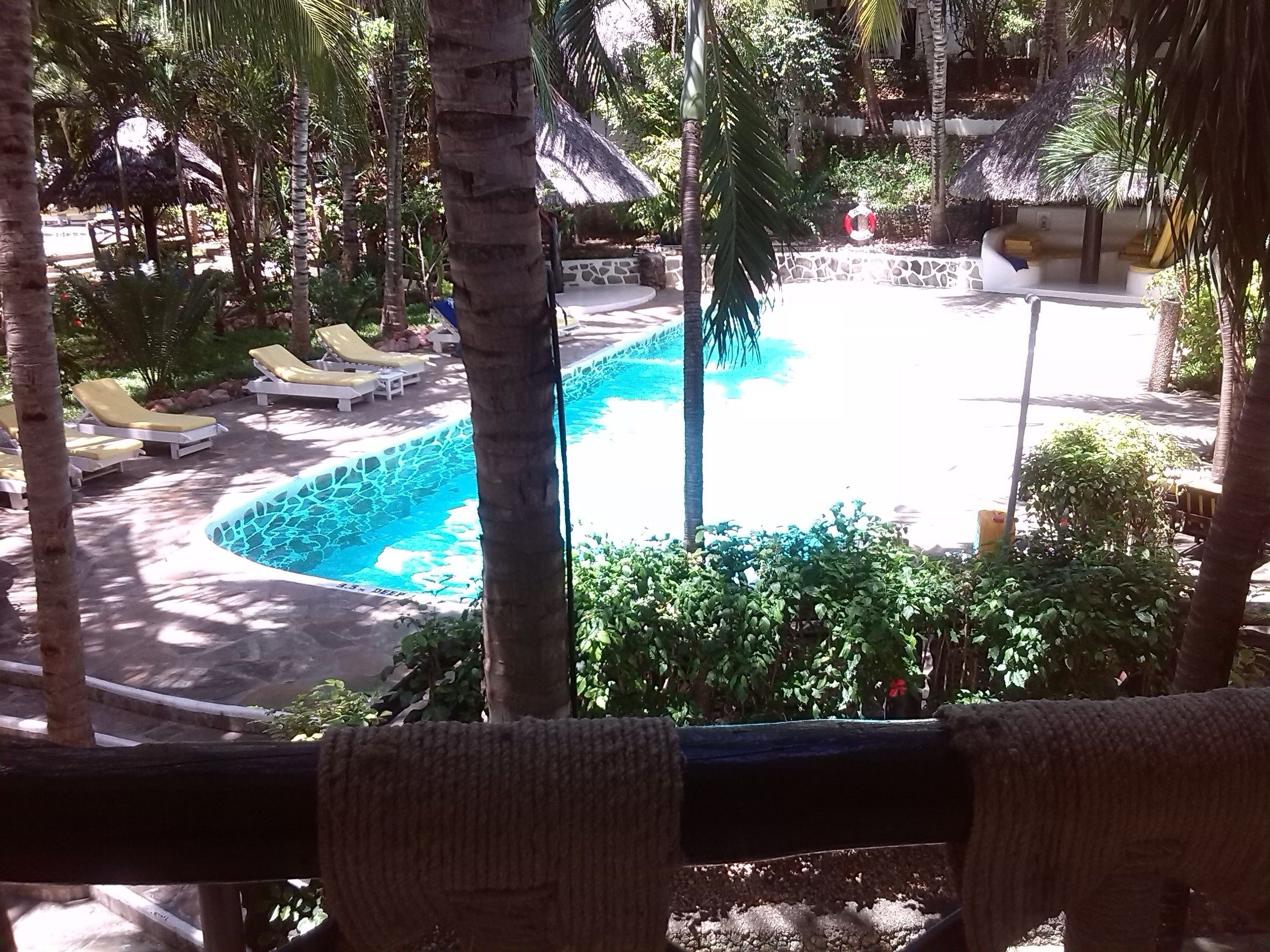 Un espace piscine avec des chaises longues et un mur en pierre.