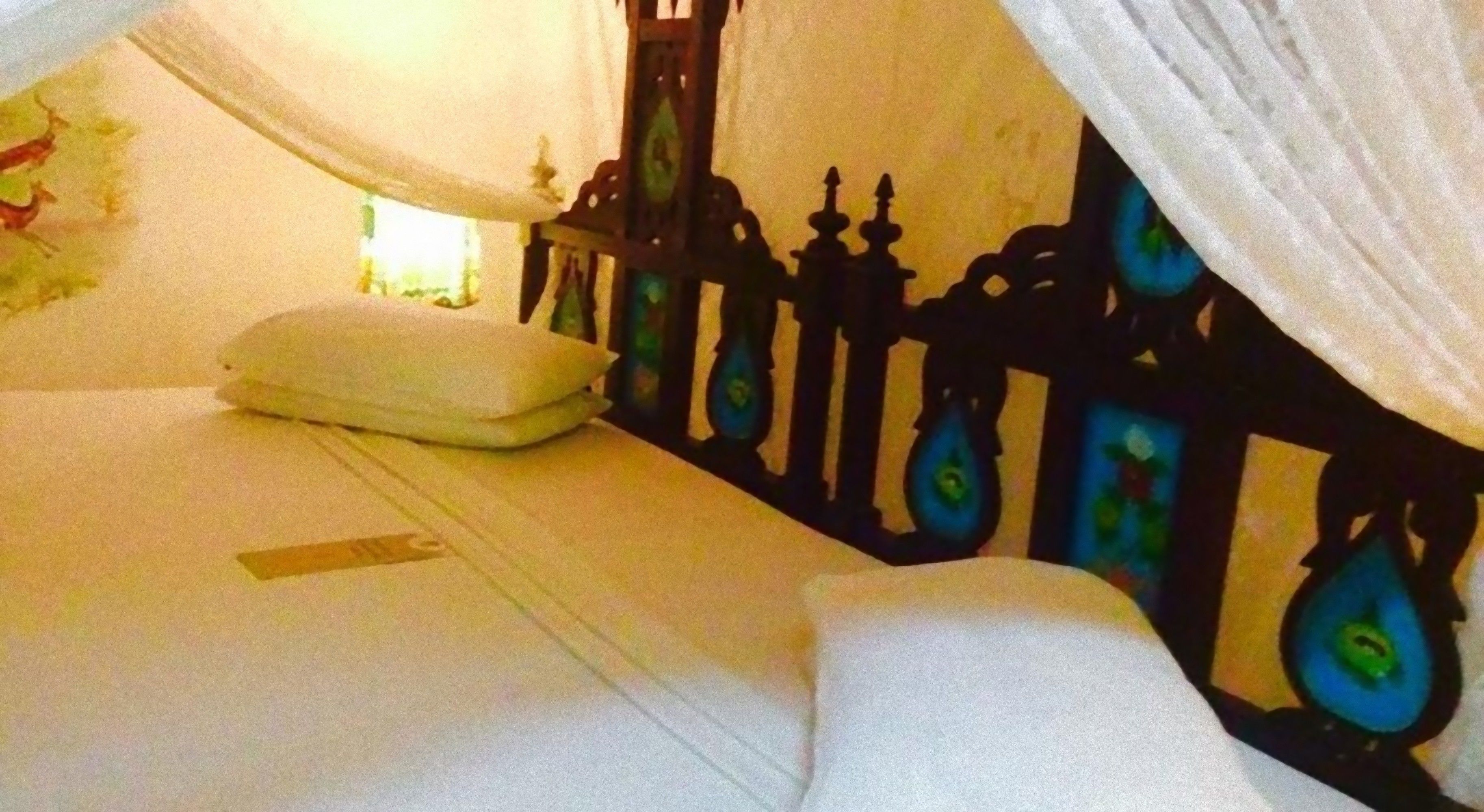 A bedroom with a bed, a nightstand, and a decorative wall.