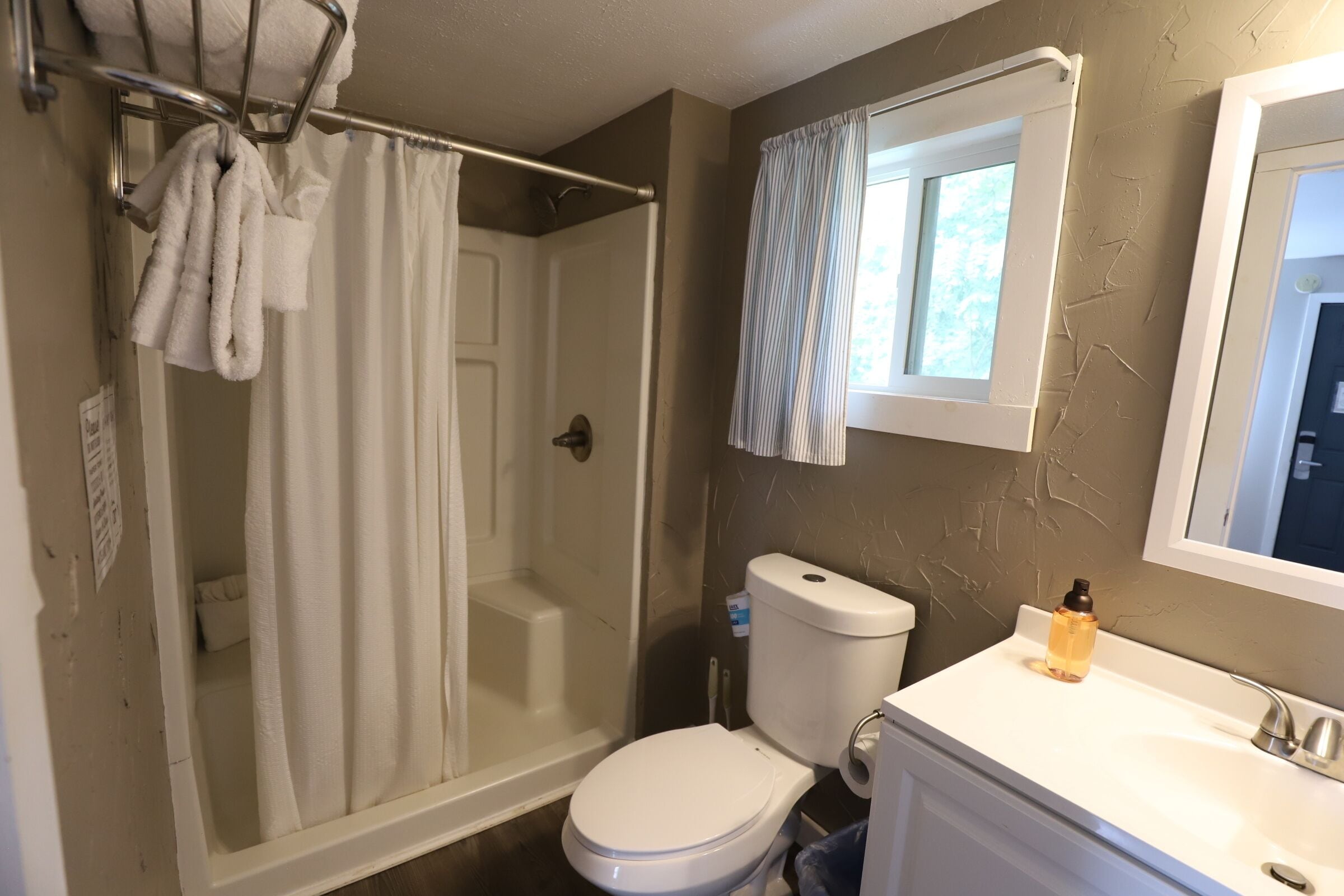 A bathroom with a shower, toilet, and sink.