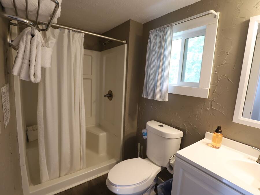 A bathroom with a shower, toilet, and sink.