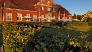 A large red brick building with multiple windows and a sloped roof. - Godstedlund B&B (Oster Ulslev)