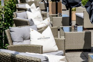 Wicker outdoor seating with cushions and a sign reading "MOËT & CHANDON CHAMPAGNE". - Godstedlund B&B (Oster Ulslev)