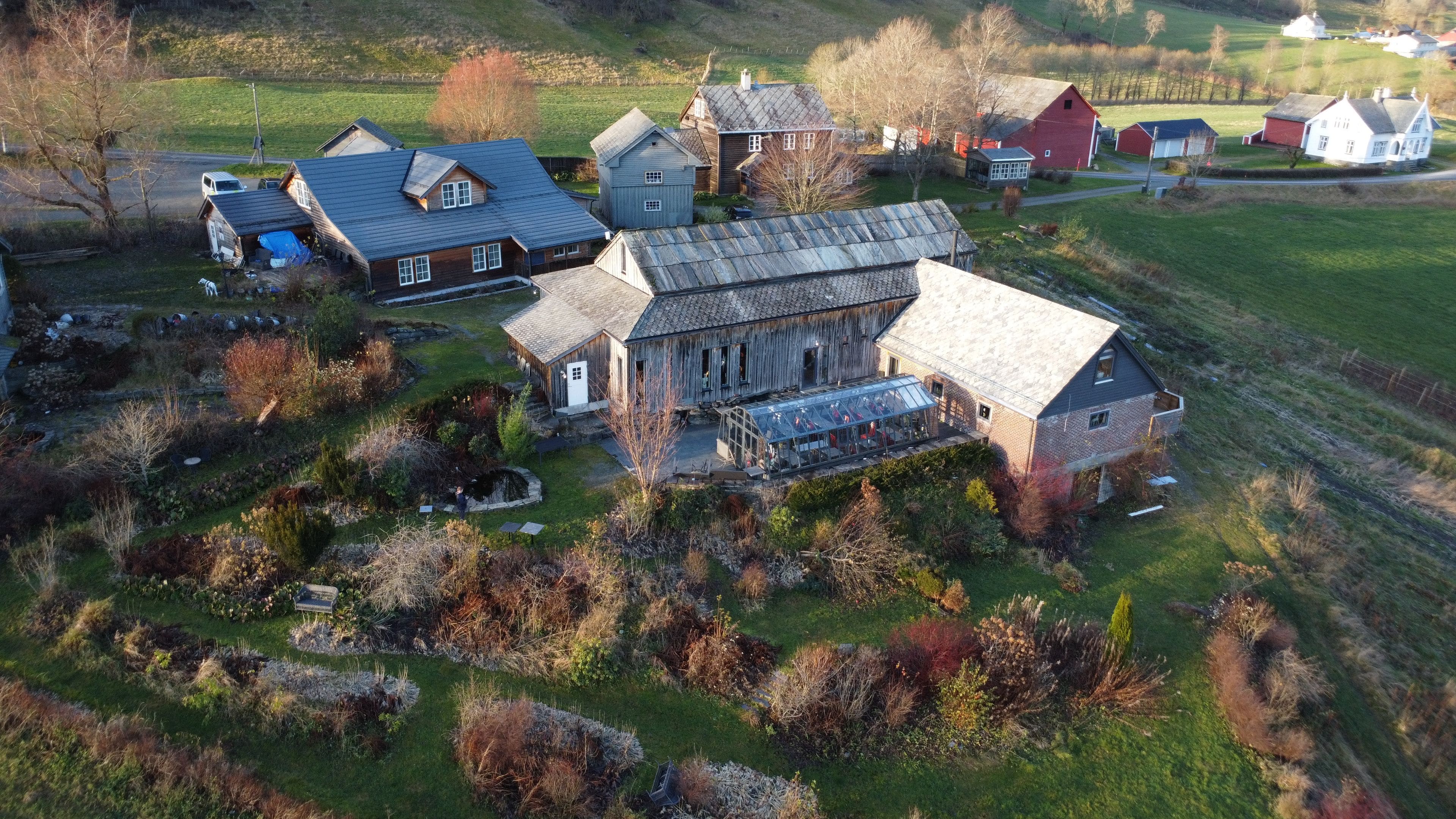 An aerial view of a rural property with multiple buildings, including a large barn and residential houses.