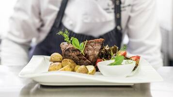 A chef's plate with steak, potatoes, and a salad.
