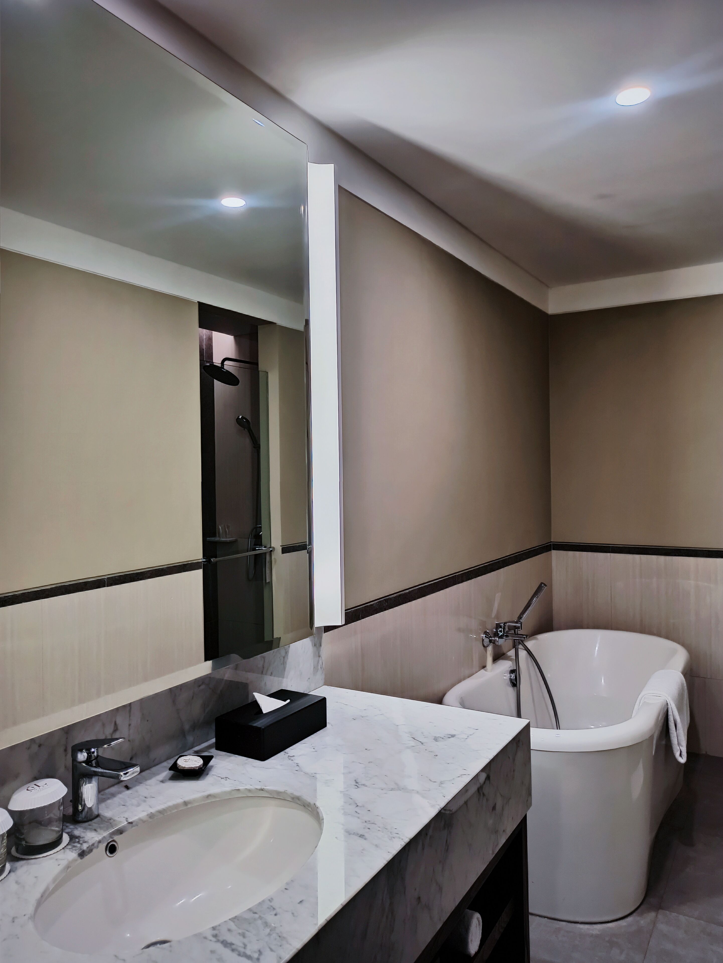 Une salle de bain moderne avec un grand lavabo, un miroir et une baignoire.
