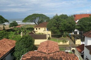 A coastal residential area with houses, trees, and a beach in the background. - Fortkochi Beach Inn (Kochi)