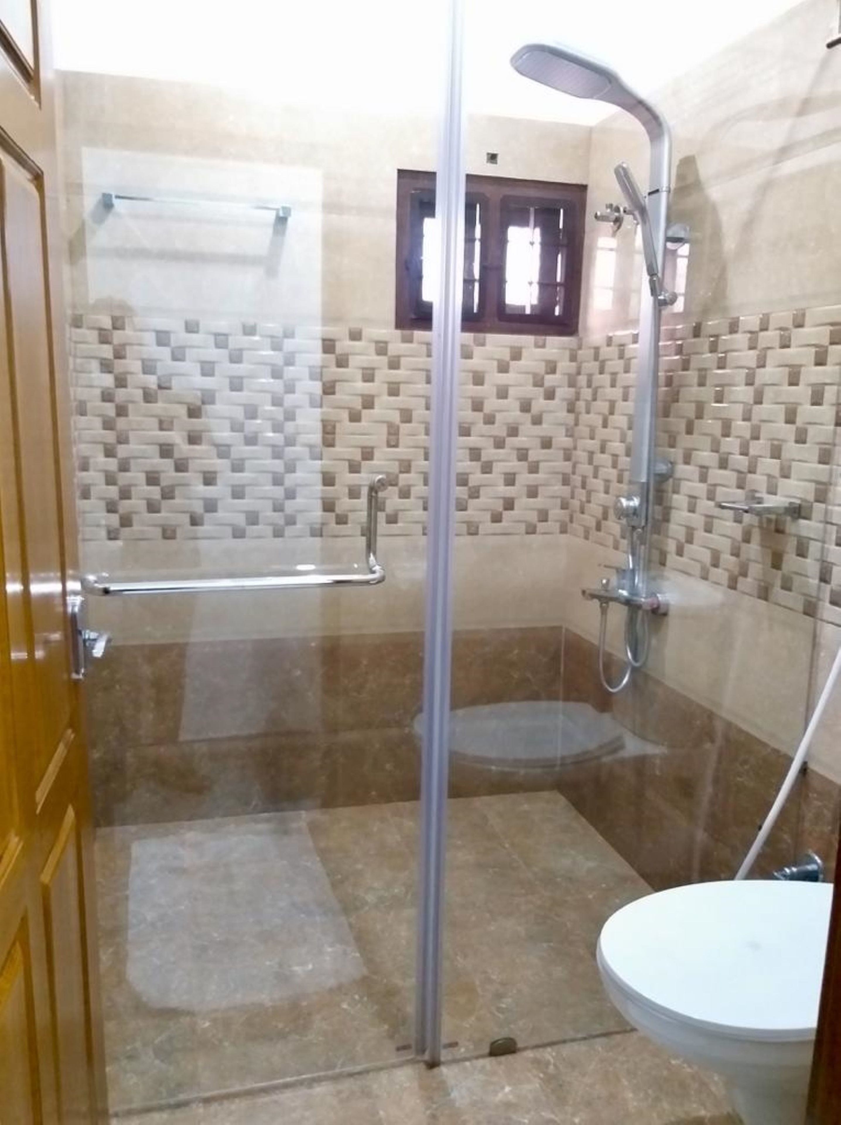 Een badkamer met een douchecabine, toilet en wastafel.