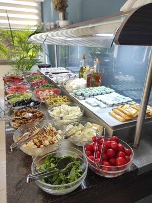 A buffet with various food items including fruits, cheeses, and condiments. - Cilek Marina Hotel (Cesme)