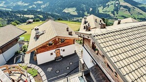 Un borgo montano con case in legno tradizionali e vista sulle colline circostanti.