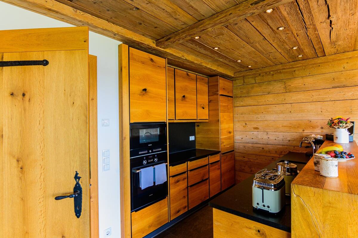 Un interior de madera con cocina, que incluye armarios, estufa y refrigerador.