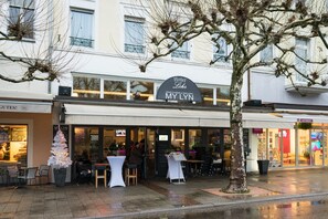 A hotel with a sign reading "Hotel Lohn My Lyn" and a restaurant with outdoor seating. - Hotel Loehr (Baden-Baden)