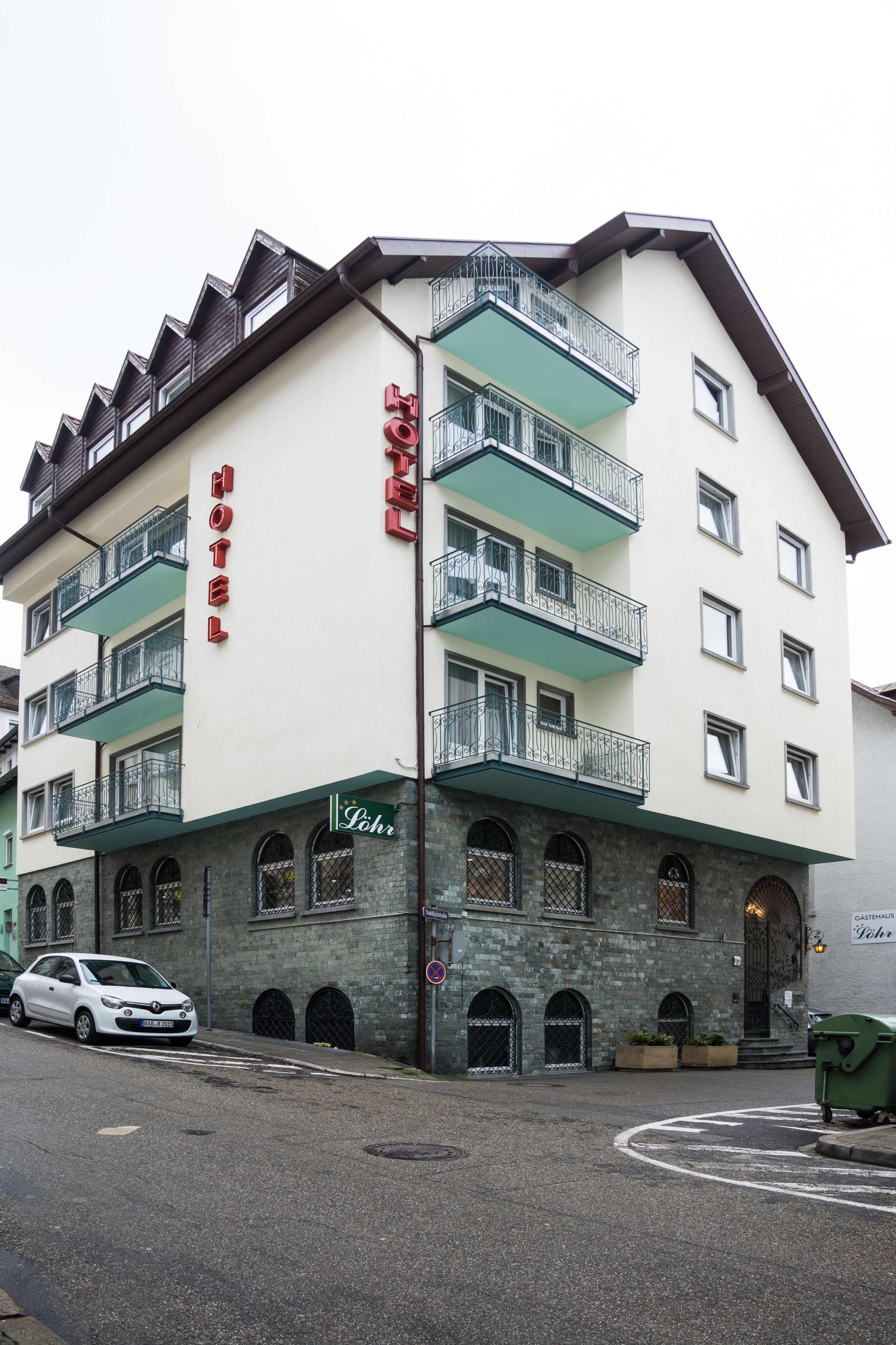A multi-story hotel with a prominent "HOTEL" sign, balconies, and a stone facade.