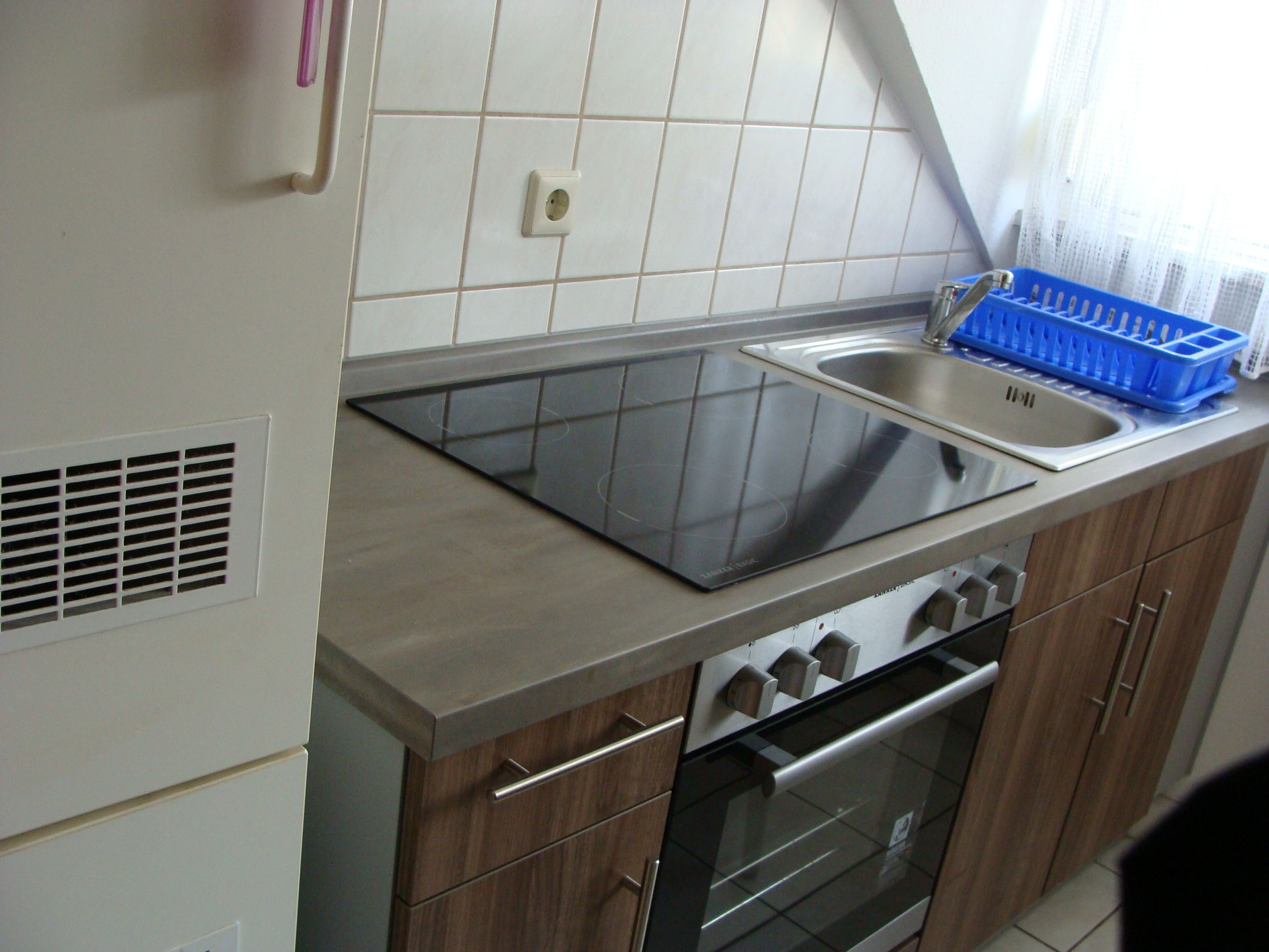 Uma cozinha moderna com fogão, forno e pia embutidos.