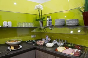 A buffet setup with various food items and condiments. - Hotel Loehr (Baden-Baden)