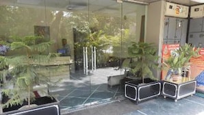 A reception area with glass doors, potted plants, and a tiled floor. - ZUZU Hemkunt (New Delhi)