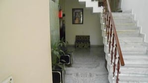 A staircase with a wooden handrail leading to a landing. - ZUZU Hemkunt (New Delhi)