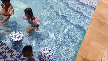 Una piscina al aire libre de temporada, sombrillas