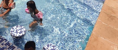 Una piscina al aire libre de temporada, sombrillas