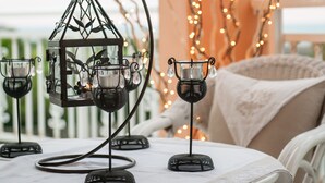 Una mesa dispuesta con candelabros de vidrio y un farol decorativo de metal.
