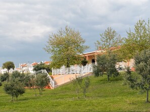 A hillside property with a staircase leading to a building with a red roof. - Villa Elaia Mare (Komotini)