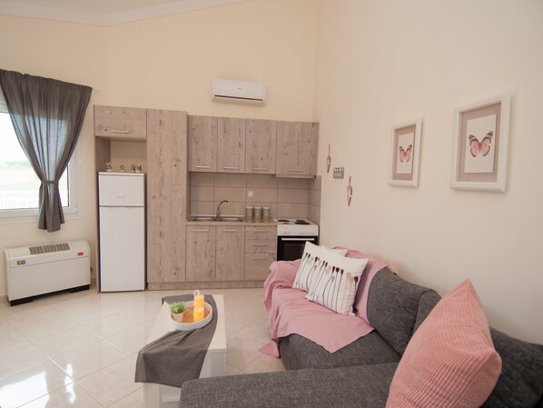 A modern apartment with a kitchenette, a dining area, and a living room. - Villa Elaia Mare (Komotini)
