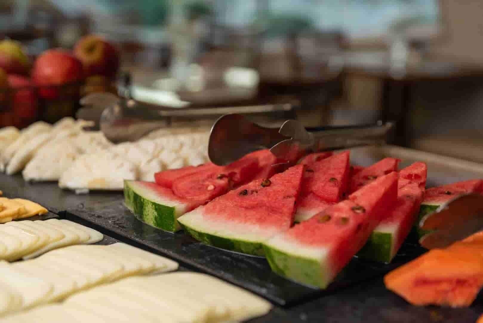 A buffet with various food items including sliced watermelon and other fruits.