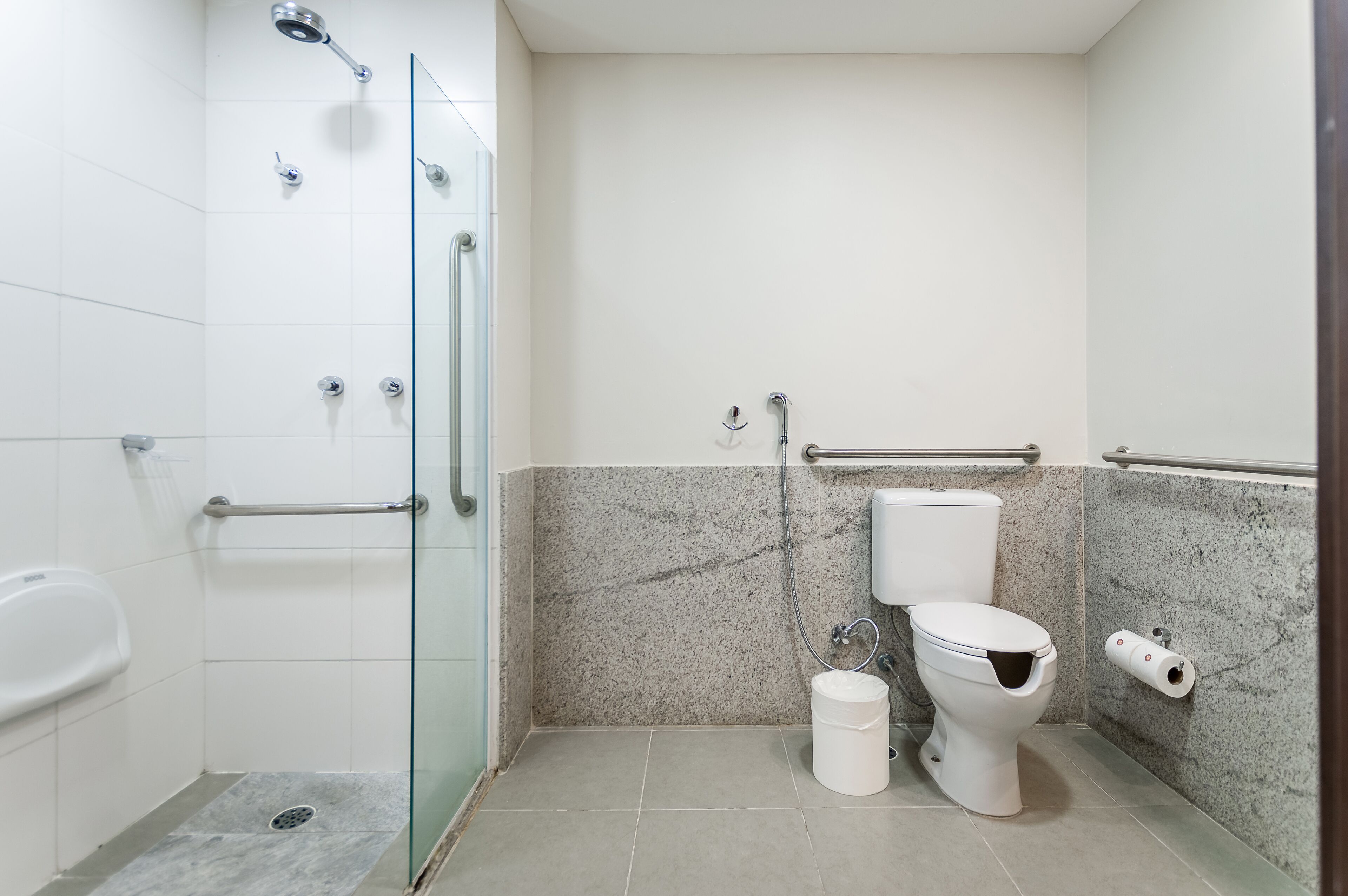 A modern bathroom with a glass shower enclosure, a toilet, and a bidet.