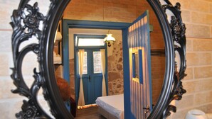 Um quarto com uma cama, uma porta e um espelho.