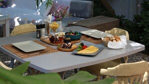 Une table à manger avec différents plats, notamment un saladier de salade, une assiette de pain et une assiette d’œufs.