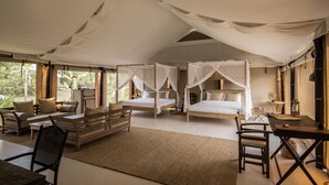 A spacious room with two beds, a sofa, a dining table, and a chair. - The Beige (Angkor Thum)