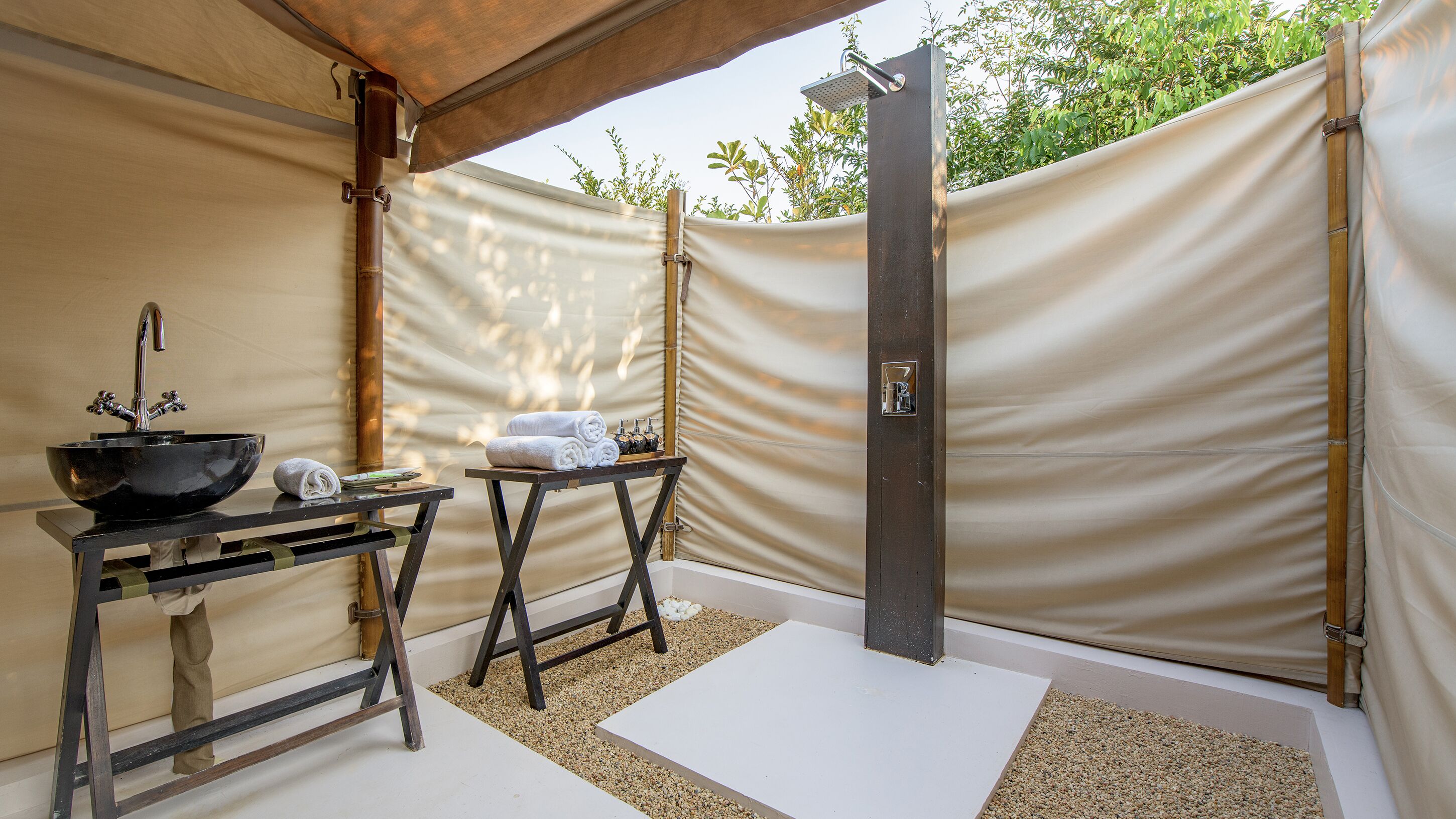 A spa area with a black sink, towels, and a shower.