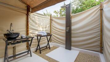 A spa area with a black sink, towels, and a shower.